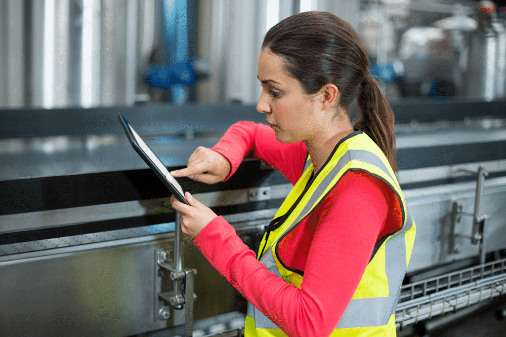 Worker reviewing data on a tablet in manufacturing environment