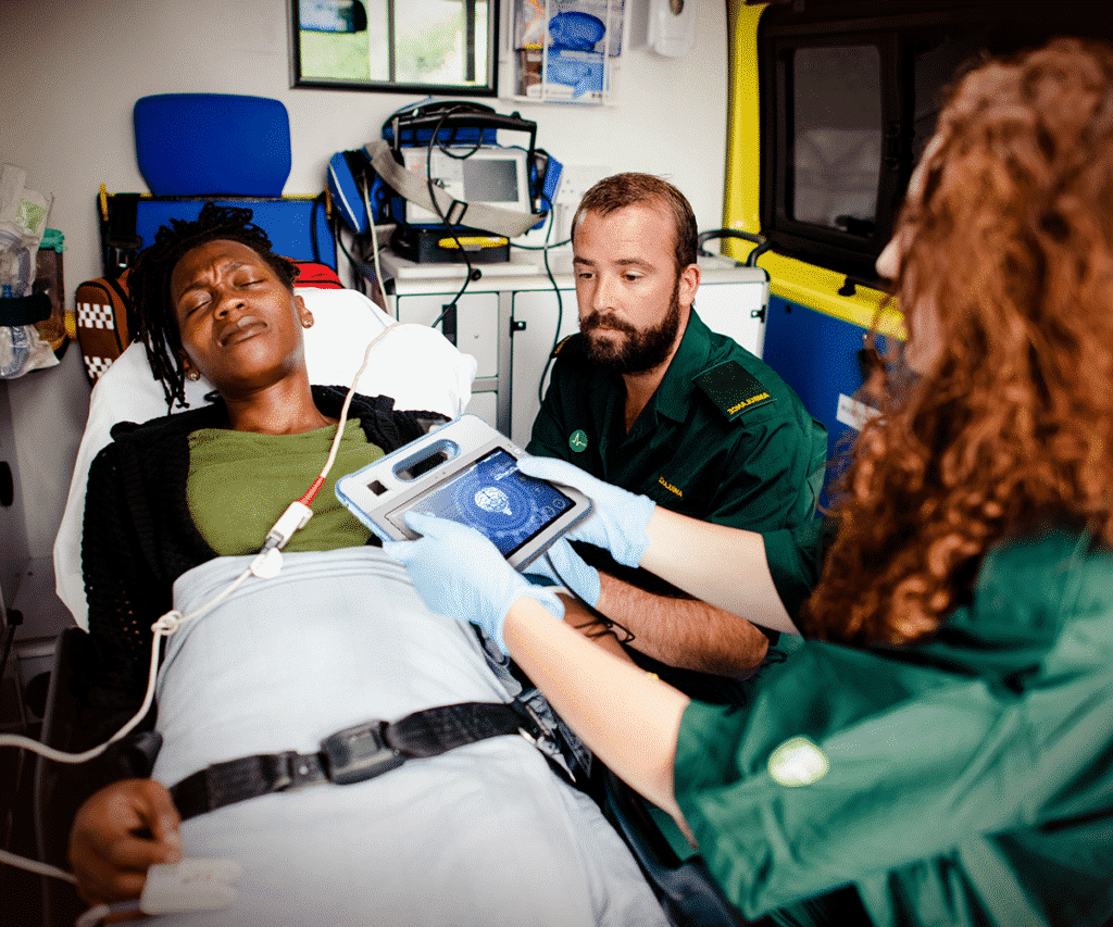 EMS personnel using the MD-100M to care for a patient in an ambulance