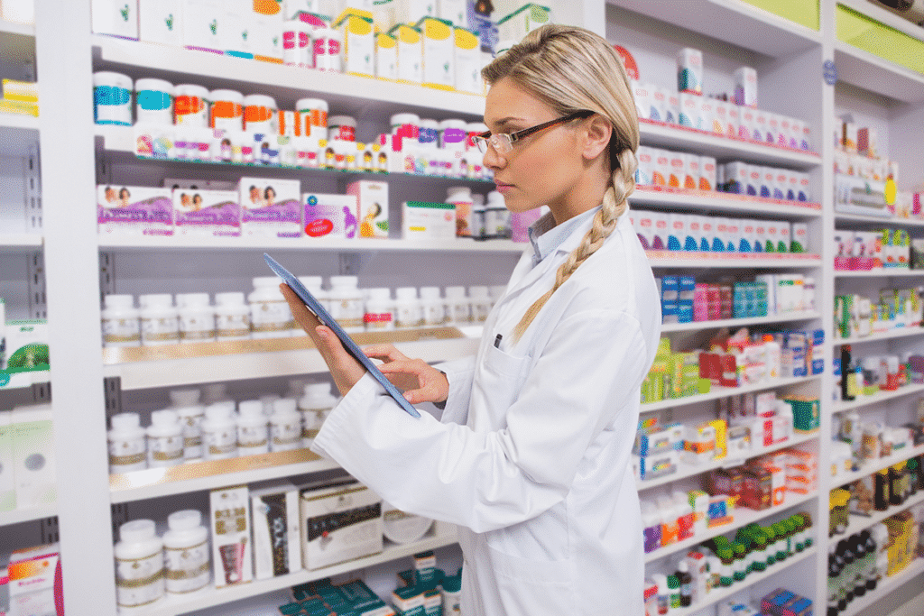 Pharmacist using a tablet to review inventory and review medical records