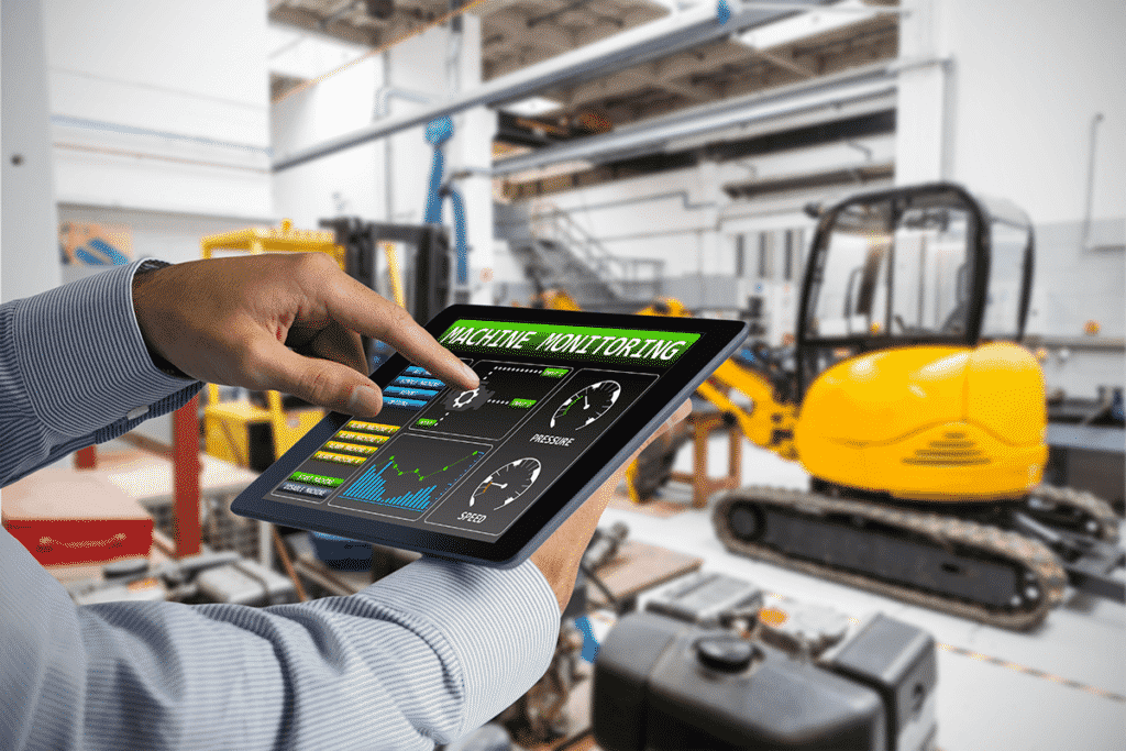 Worker using a tablet to monitor smart factory automated equipment